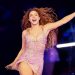 Cantora com vestido rosa brilhante e cabelo cacheado solto, sorrindo e com um braço estendido durante apresentação em palco iluminado.
A cantora Shakira em Buenos Aires, no ano passadop - Agustin Marcarian/Reuters