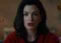 Anne Hathaway como Verity Crawford, com blusa vermelha, em cena do filme Verity.
