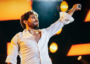 Cartaz de Inconfundível Tour com Gustavo Mioto no palco, de camisa branca e microfone na mão