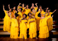 Elenco de Marrom, o Musical em cena, com figurinos amarelos