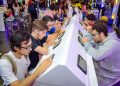 Jovens utilizam tablets em bancadas de atendimento do CIEE, em um espaço de orientação e oportunidades.