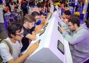 Jovens utilizam tablets em bancadas de atendimento do CIEE, em um espaço de orientação e oportunidades.