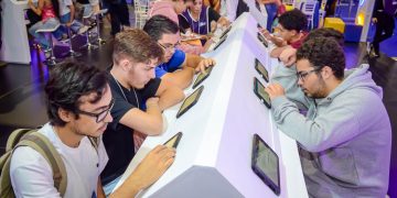 Jovens utilizam tablets em bancadas de atendimento do CIEE, em um espaço de orientação e oportunidades.