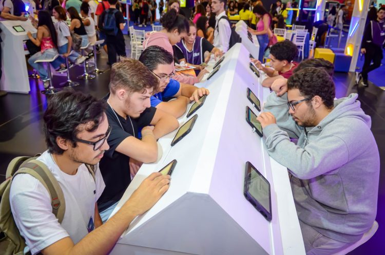 Jovens utilizam tablets em bancadas de atendimento do CIEE, em um espaço de orientação e oportunidades.