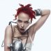 FKA twigs com cabelos vermelhos, maquiagem escura e figurino de peças metálicas em foto de divulgação.