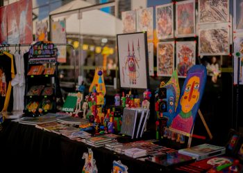 Estande da Feira MOTIM com livros, ilustrações, brinquedos artísticos e obras de arte impressa