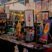 Estande da Feira MOTIM com livros, ilustrações, brinquedos artísticos e obras de arte impressa
