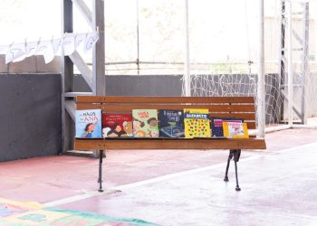 Livros infantojuvenis expostos em um banco de madeira durante atividade da Flipiri.