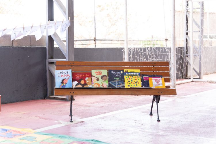Livros infantojuvenis expostos em um banco de madeira durante atividade da Flipiri.