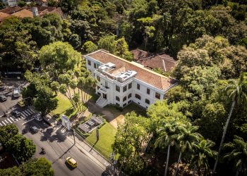 Vista aérea do prédio do Museu do Jardim Botânico, cercado por árvores no Rio de Janeiro.