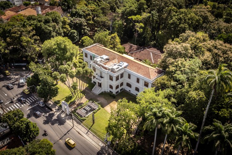 Vista aérea do prédio do Museu do Jardim Botânico, cercado por árvores no Rio de Janeiro.