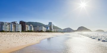 Vista panorâmica da Praia de Copacabana, com mar, faixa de areia e edifícios da orla do Rio de Janeiro