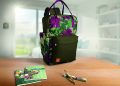 Mochila, cadernos e caneta da linha Natura Crer Para Ver sobre uma mesa
