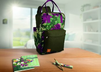 Mochila, cadernos e caneta da linha Natura Crer Para Ver sobre uma mesa