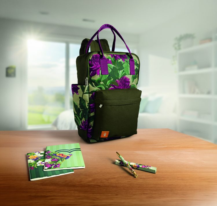 Mochila, cadernos e caneta da linha Natura Crer Para Ver sobre uma mesa
