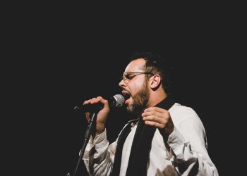 Vocalista da banda Sereníssima canta ao microfone em foto de divulgação