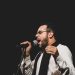 Vocalista da banda Sereníssima canta ao microfone em foto de divulgação