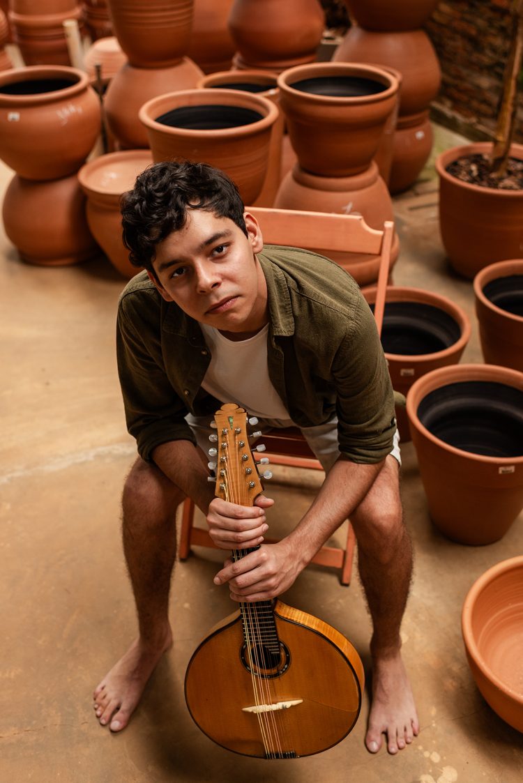 Tiago Tunes sentado com bandolim de 10 cordas. Foto: Van Papillo.