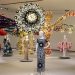 Vista oficial de VENUS no MAAT: manequins com vestidos de Valentino diante da instalação têxtil monumental de Joana Vasconcelos.