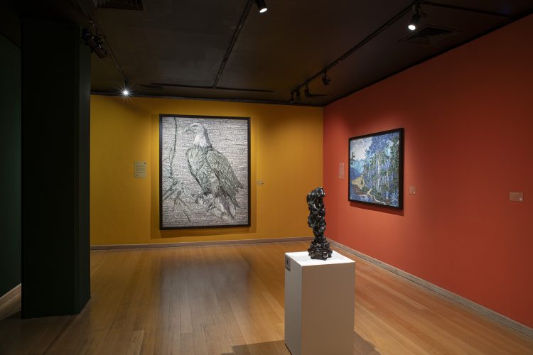 Vista da exposição de Vik Muniz no CCBB Rio de Janeiro, com fotografias em paredes amarelas e vermelhas e escultura sobre pedestal.