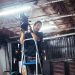 Zizi Antunes ajusta equipamento de iluminação cênica em uma escada durante atividade técnica